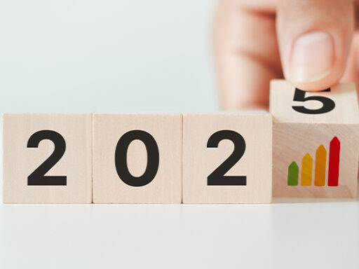 Blocs de bois indiquant l’année 2025 avec une main qui ajoute le chiffre, symbole des nouvelles obligations et évolutions du diagnostic immobilier