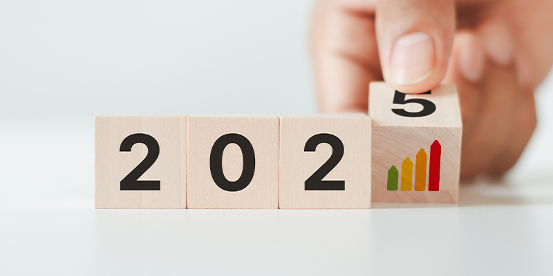 Blocs de bois indiquant l’année 2025 avec une main qui ajoute le chiffre, symbole des nouvelles obligations et évolutions du diagnostic immobilier